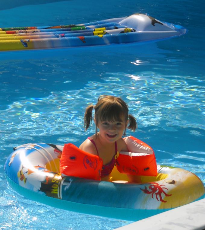 Kind auf Schlauchboot im Pool Kind auf Schlauchboot im Pool