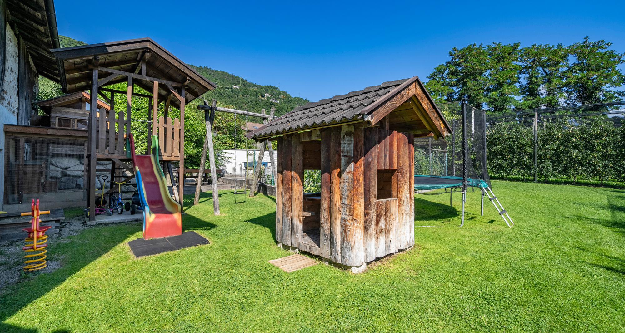 Spielplatz mit Trampolin, Rutsche und Spielhäuschen